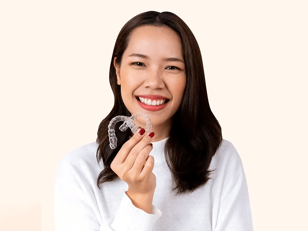 close up young beautiful woman smiling with hand holding dental aligner retainer close up young beautiful woman smiling with hand holding dental aligner retainer