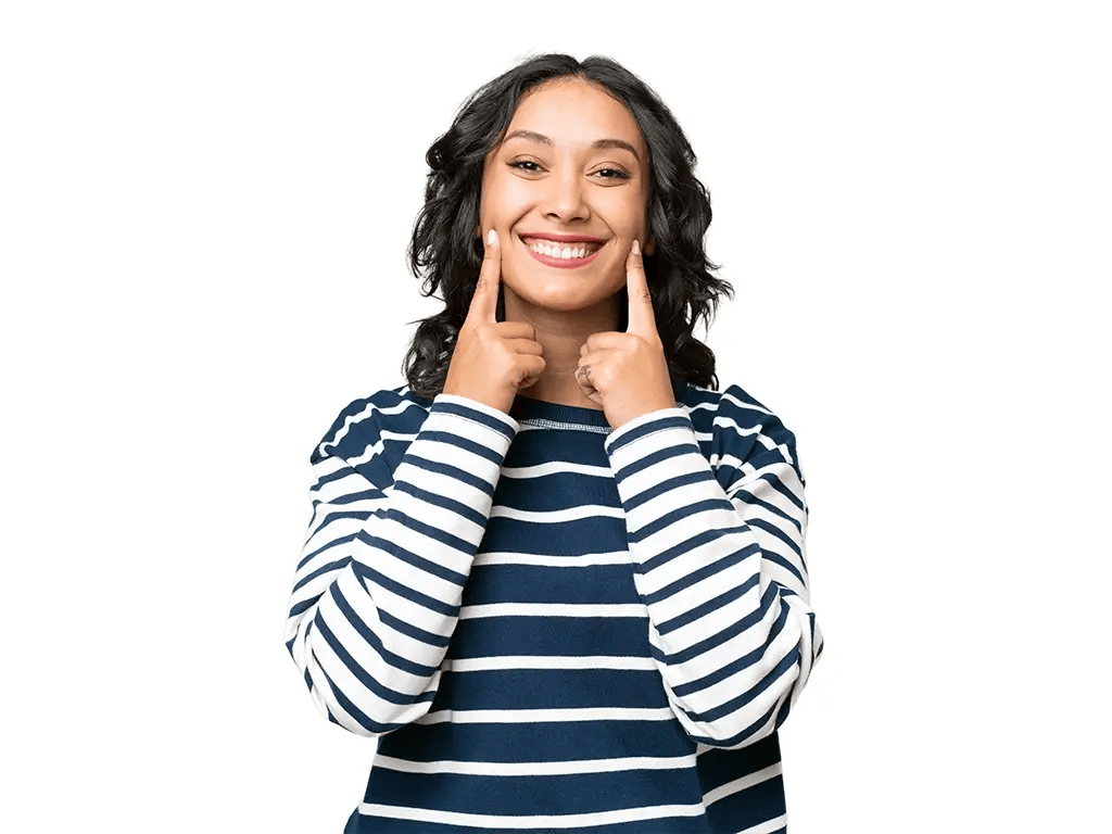 young woman smiling and pointing at her pretty smile